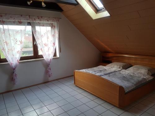 ein Schlafzimmer mit einem Bett und zwei Fenstern in der Unterkunft Ferienwohnung Hilker in Hessisch Oldendorf