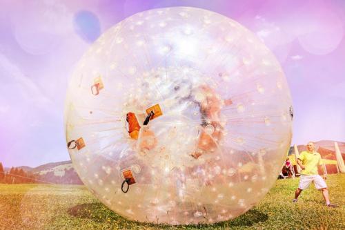 a man standing inside of a large ball in a field at Appartement Alpenfex in Flachau