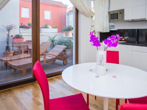 a dining room with a white table and red chairs at City Square in Zadar