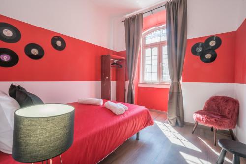 リスボンにあるCais do Sodre - nearby Pink Street, Time Out Market by LD Apartmentsの赤と白のベッドルーム(赤のベッド1台、椅子付)