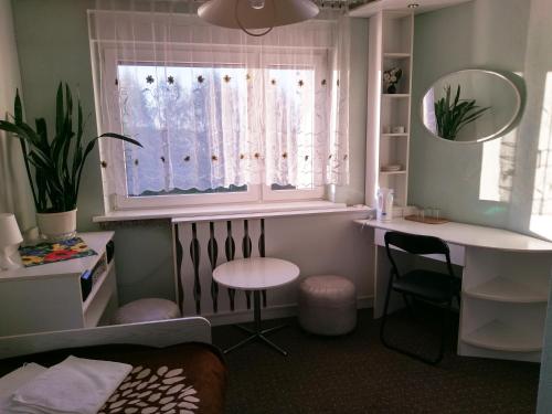 a bedroom with a window and a table and a desk at Agroturystyka Gramburg in Zblewo