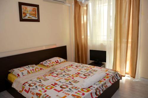 1 dormitorio con cama con edredón en Ivet Apartment, en Varna