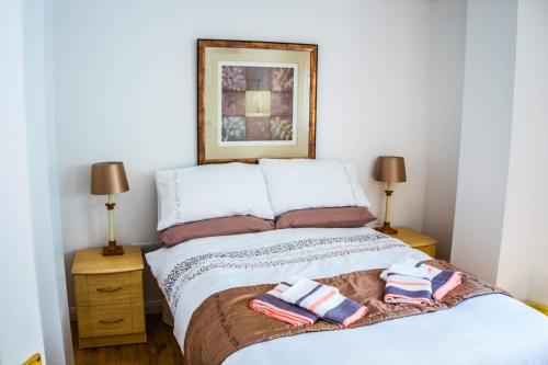 a bedroom with a bed with two towels on it at Tower View Apartment in Cushendall