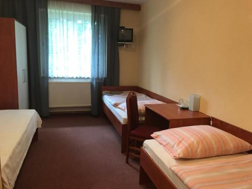 Pokój hotelowy z 2 łóżkami, stołem i biurkiem w obiekcie Chata Rosa w mieście Malenovice