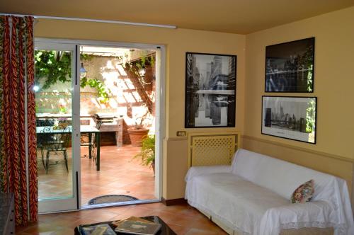 sala de estar con sofá y patio en Casa Magnolia en Gravina di Catania