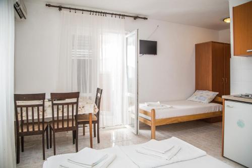 a room with a table and a bed and a dining room at Apartmani Ksenija in Petrovac na Moru
