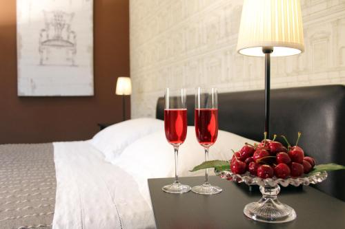 twee wijnglazen op een tafel naast een bed bij Bigarò in Conversano