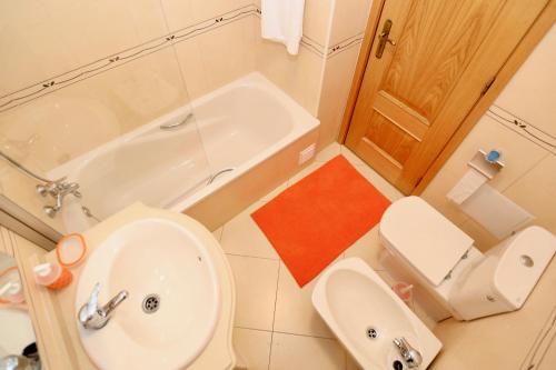 アルマカオ・デ・ペラにあるDa Ponte Flats - Armacao De Pera Orange Aptのバスルーム(トイレ、洗面台、バスタブ付)