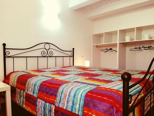 a bedroom with a bed with a colorful quilt at Green Holidays in Castellammare del Golfo