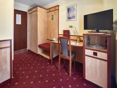 a hotel room with a desk and a television at Hotel Alfa Zentrum in Munich
