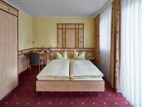 a bedroom with a bed and a desk in it at Hotel Alfa Zentrum in Munich