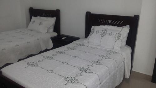 two beds sitting next to each other in a bedroom at Hotel La Vieja Sara in Valledupar