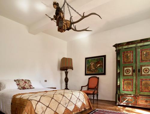 a bedroom with a bed and a chandelier at Le dimore de Il borgo del balsamico in Albinea