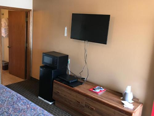 a hotel room with a television and a bed at Exxon Quik Stop & Motel in Wausaukee