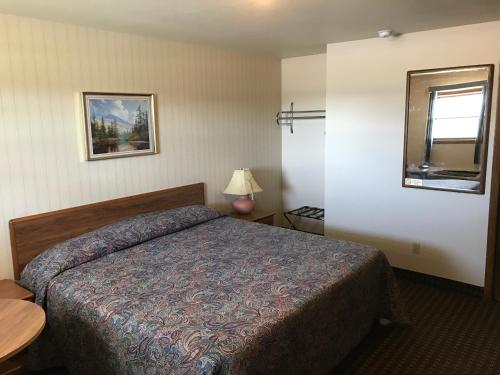 una camera d'albergo con letto e specchio di Exxon Quik Stop & Motel a Wausaukee