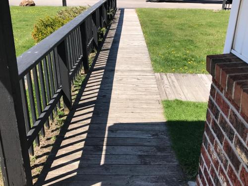 a wooden walkway next to a brick fence at Exxon Quik Stop & Motel in Wausaukee