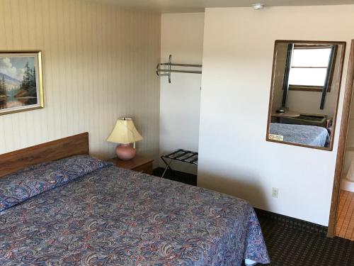 a hotel room with a bed and a mirror at Exxon Quik Stop & Motel in Wausaukee