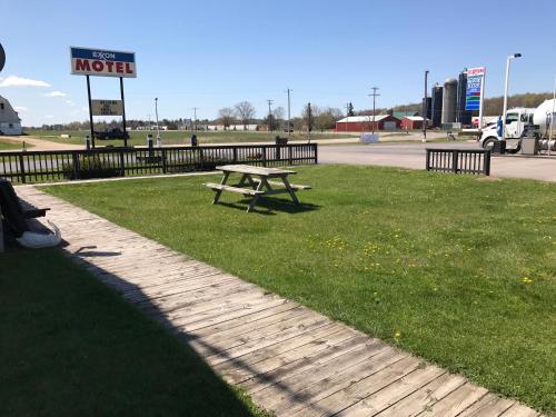 a picnic table in the grass next to a motel sign at Exxon Quik Stop & Motel in Wausaukee