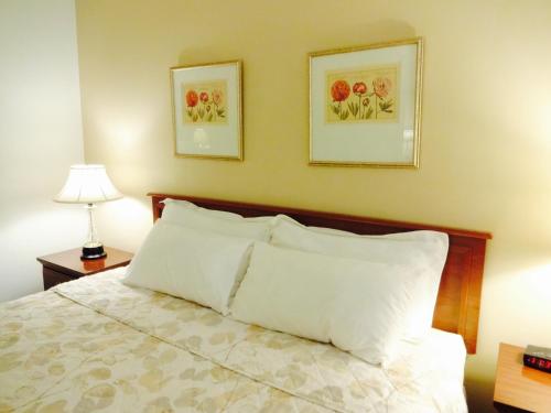 a bedroom with a bed with two pictures on the wall at Gorham Motor Inn in Gorham