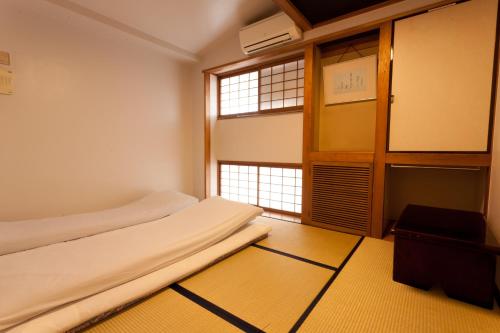 a small room with a bed and a window at Kimi Ryokan in Tokyo