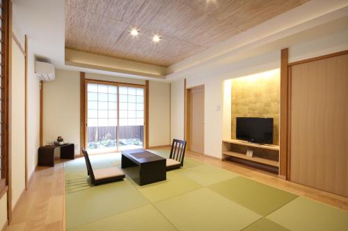 a living room with a table and a tv at Chikurakutei in Minami Aso