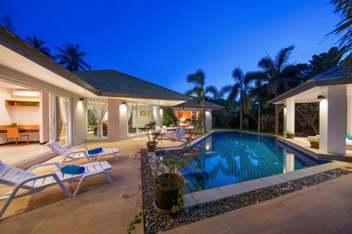 a villa with a swimming pool at night at Lipa Talay Haa in Lipa Noi