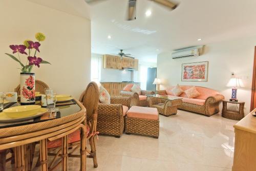 a living room with a couch and a table at BUTTERFLY GARDEN BOUTIQUE RESIDENCES Apts and villas, A Lifestyle Destination Ex Lg 1-3 bedroom units , Full kitchen, 2 Full bathrooms, Rain shower, Spa bath, FREE BBQ, Free fast fiber optic WIFI, Staff 24-7 in Pattaya South