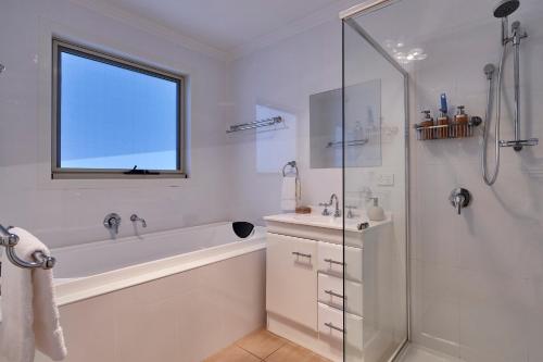 a bathroom with a tub and a sink and a shower at Esperance Landing in Dover