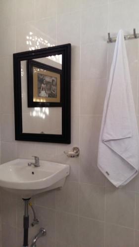 a white bathroom with a sink and a mirror at Manik House in Ubud