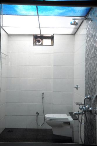 a bathroom with a toilet and a window and a shower at JS Excellency in Mahabaleshwar