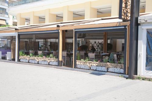 a store front of a building with tables and chairs at Paliria Hotel in Chalkida