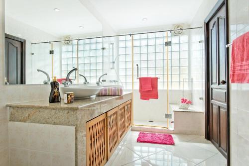 a bathroom with a sink and a shower at BUTTERFLY GARDEN BOUTIQUE RESIDENCES by Frasier, A Lifestyle Destination Apt and Villas 1 to 3 Bedroom units, 2 Full Bathrooms, Rain shower, Spa bath, Complete kitchen, Staff 24-7,Fast fiber optic WIFI, 55" SMART TV's, Free BBQ, in Pattaya South