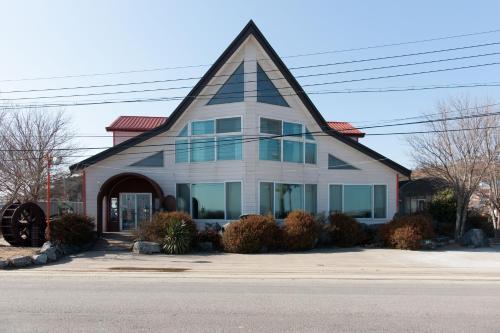 a house with a triangular roof on a street at Sunrise Pension in Hwaseong