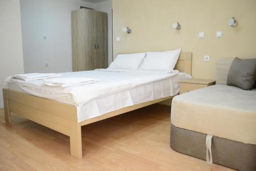 a bedroom with two beds with white sheets at Villa Konzuli in Bitola