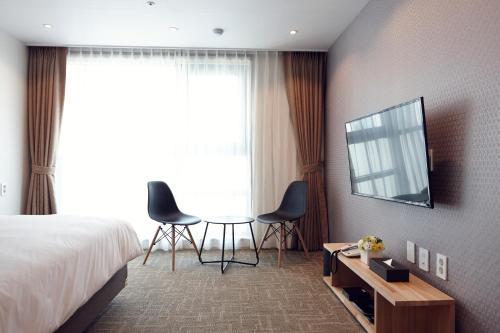 a hotel room with a bed and a table and chairs at Royal Square Hotel Seoul in Seoul
