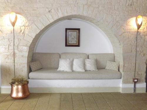 un sofá en una habitación con una pared de ladrillo en Masseria Colombo, en Mottola