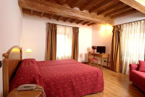 a bedroom with a red bed and a red couch at HG Abetone e Piramidi Resort in Abetone