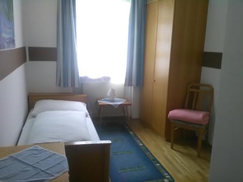 格里斯基興的住宿－Gasthof Schatzl，一间小卧室,配有一张床、一把椅子和一个窗户