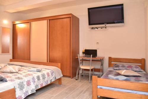 a bedroom with two beds and a desk and a tv at Villa Valenta-Klis near Split, heated pool & view in Klis