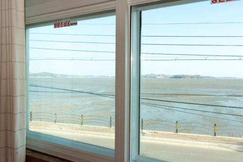 a window with a view of a field at Sunrise Pension in Hwaseong