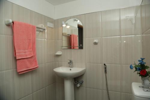 een badkamer met een wastafel en een spiegel bij Surf reef guest house in Mirissa