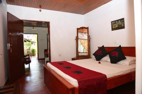 een slaapkamer met een bed met een rode deken erop bij Surf reef guest house in Mirissa