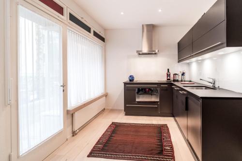 a kitchen with black appliances and a large window at Appartements Hofquartier in Luzern