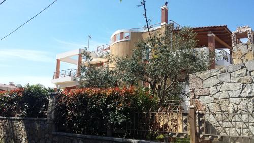 a building with a stone wall and a fence at Villa Demy in Patra