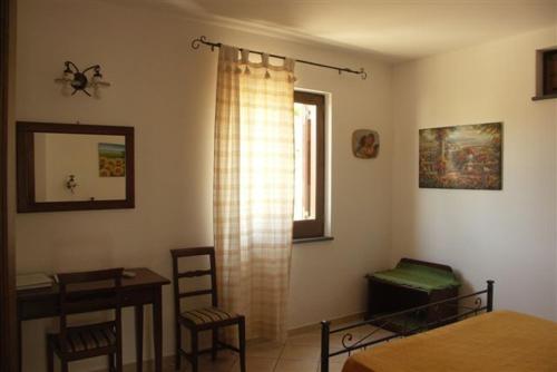 a room with a bed and a table and a window at Villa Hermes Case Vacanza in Lipari