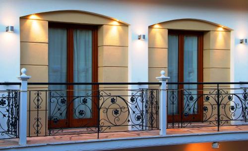 a building with a balcony with two doors at Parnassos Delphi Hotel in Delfoi