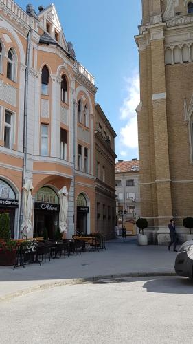 a group of buildings with tables in a courtyard at Apartment Centrum in Novi Sad