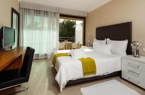 a bedroom with a bed and a desk and a television at Sunset Apartments in Podstrana