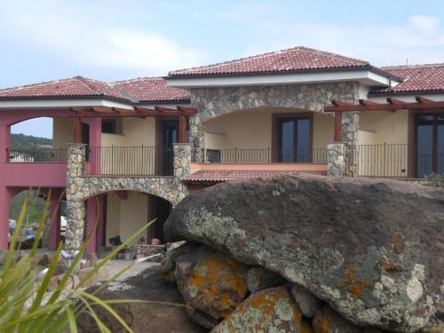 a house with a large rock in front of it at Hotel Sa Cheya Relais & Spa in Alghero