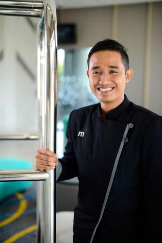 a man in a black shirt is smiling at Midtown Residence Surabaya in Surabaya
